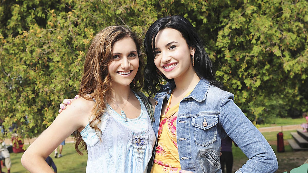 Alyson Stoner smiling alongside Demi Lovato during an episode of Disney's hit film "Camp Rock."