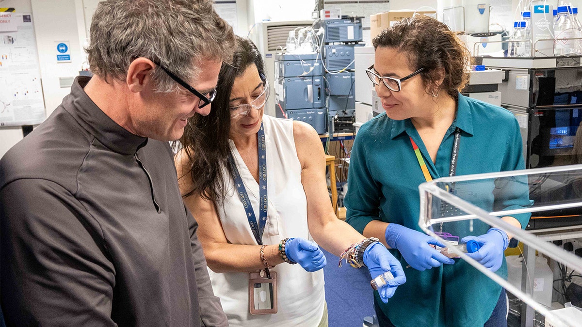 Researchers, Luciana smiling in a lab