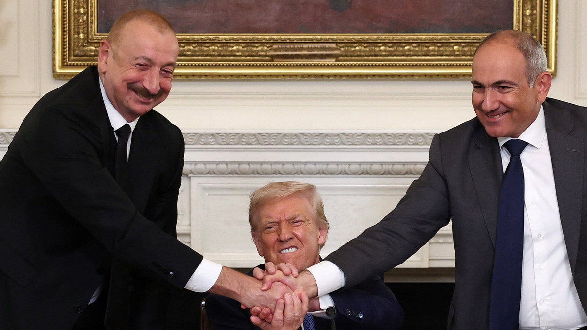 U.S. President Donald Trump holds the hands of Azerbaijan's President Ilham Aliyev and Armenia's Prime Minister Nikol Pashinyan as they shake hands between each other during a trilateral signing event, at the White House, in Washington, D.C., August 8, 2025.