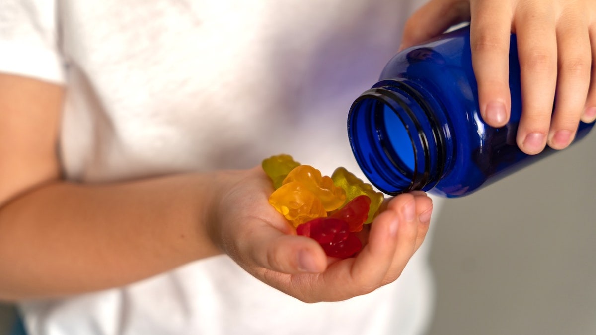 Boy taking cannabis gummies out of bottle