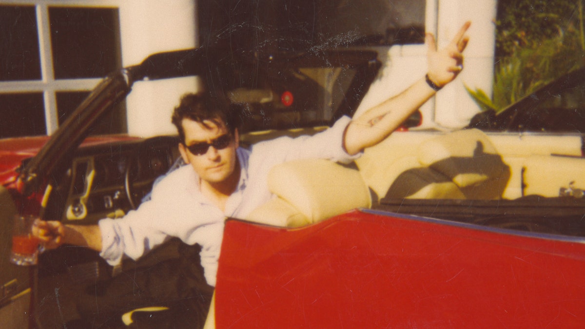 Charlie Sheen in a red car
