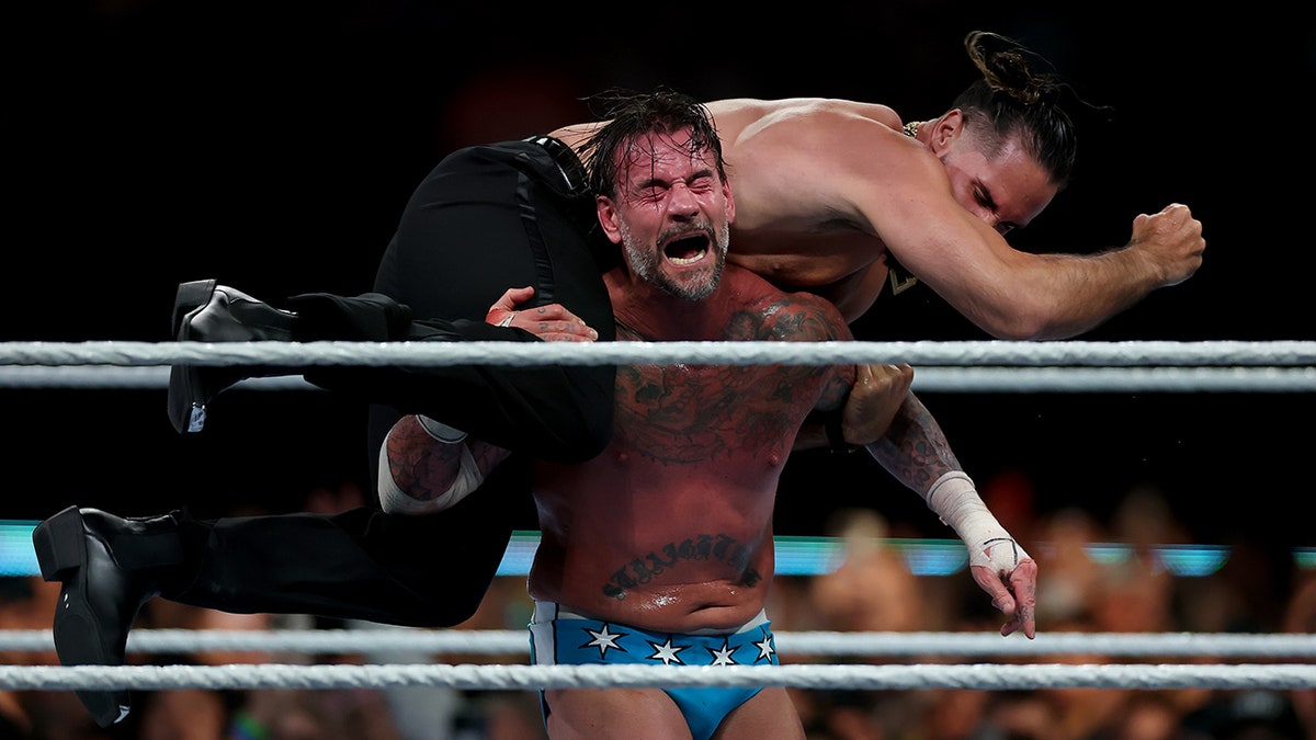 CM Punk puts Seth Rollins on his shoulders