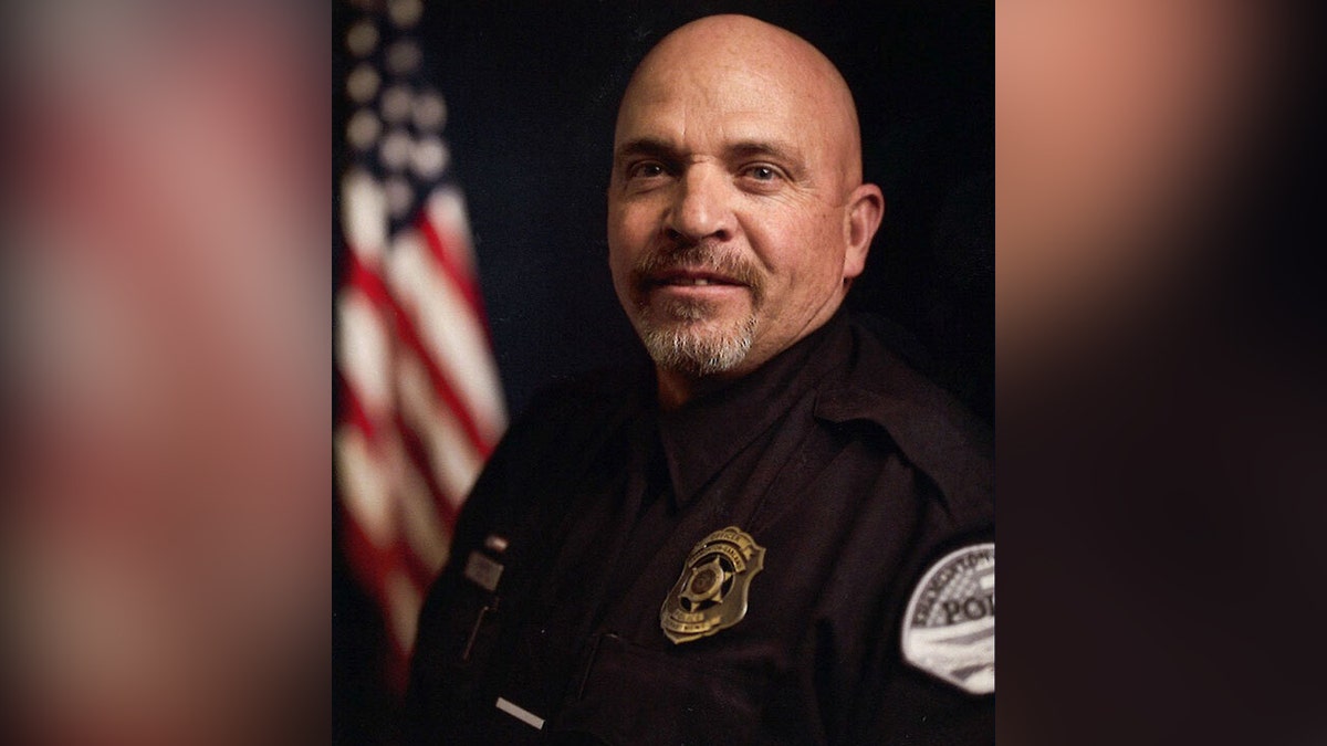 SGT. Lee Sorensen posando de uniforme na frente da American Flag