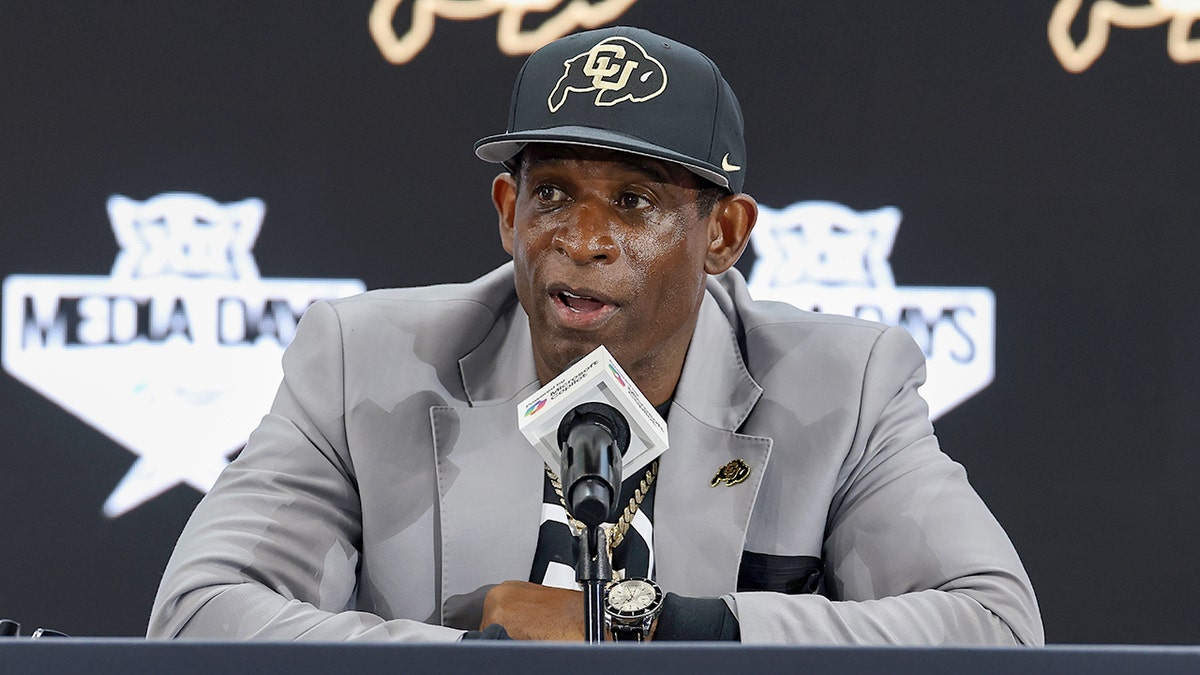 Deion Sanders talks to reporters