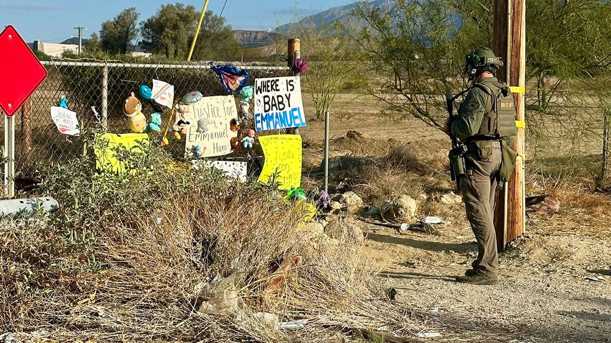 armed officer standing in front of memorial for Emmanuel