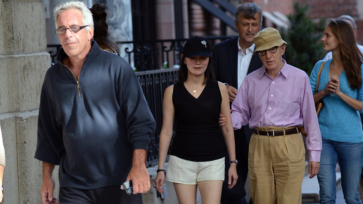 Woody Allen walks with Soon-Yi behind Jeffrey Epstein