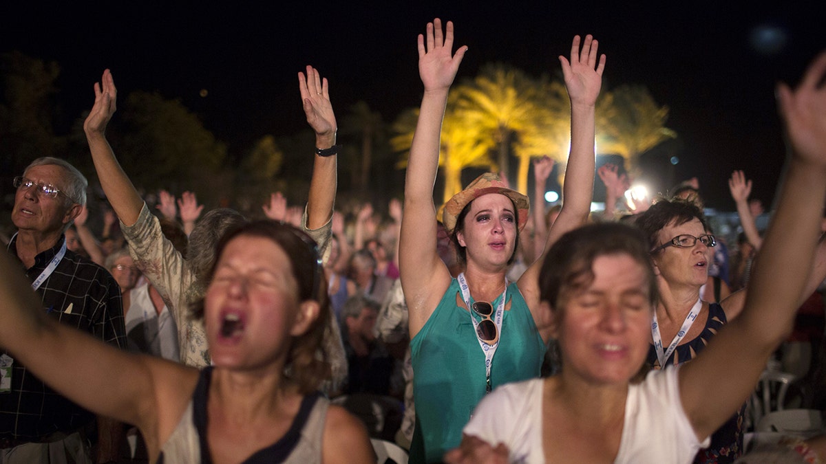 Thousands of evangelical Christian pilgrims pray during a prayer gathering on the Dead Sea shore in Ein Gedi on September 20, 2013, in the Judean Desert, during their annual visit to Israel to mark the Jewish holiday of Sukkot (Tabernacles) and to express solidarity with Israel. Some five thousand Christian pilgrims from around the world arrived for a week-long visit to Israel, in an annual show of solidarity with the Jewish state.