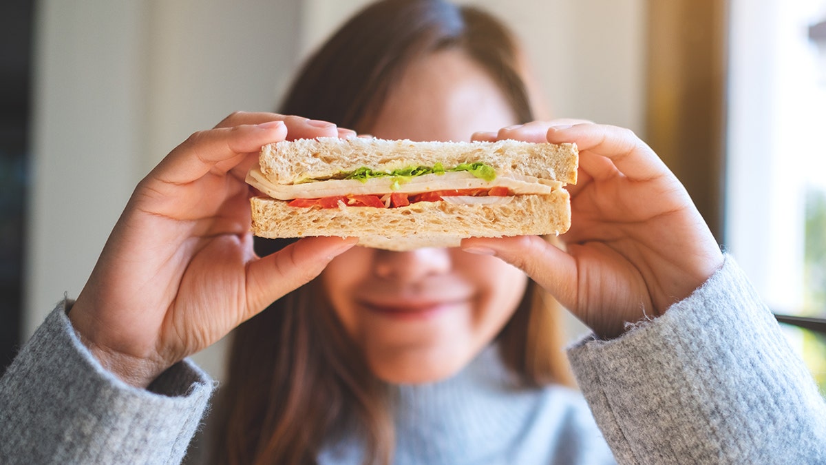 Woman holding turkey sandwich