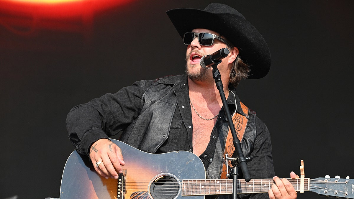 Gavin Adcock performing on stage in a black cowboy hat at the 2025 Railbird Music Festival in June.