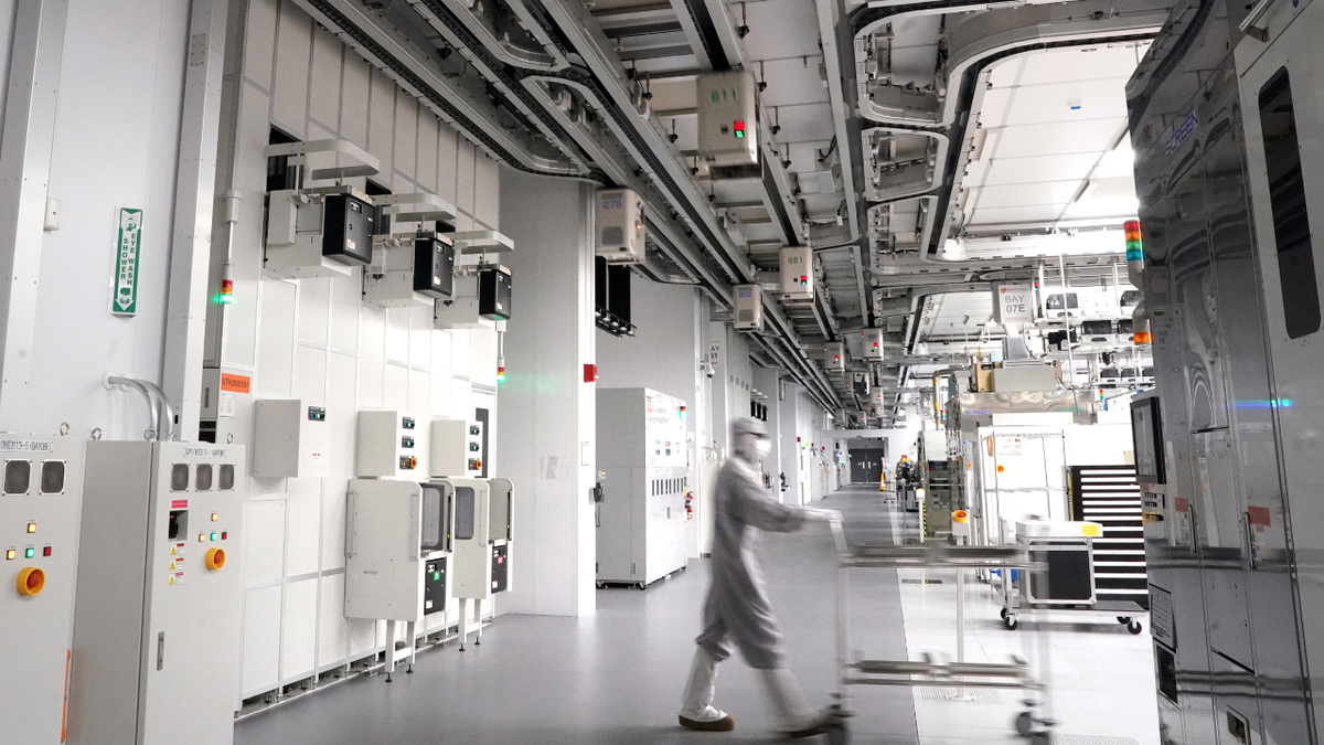 An employee walking inside of GlobalFoundries semiconductor manufacturing facility
