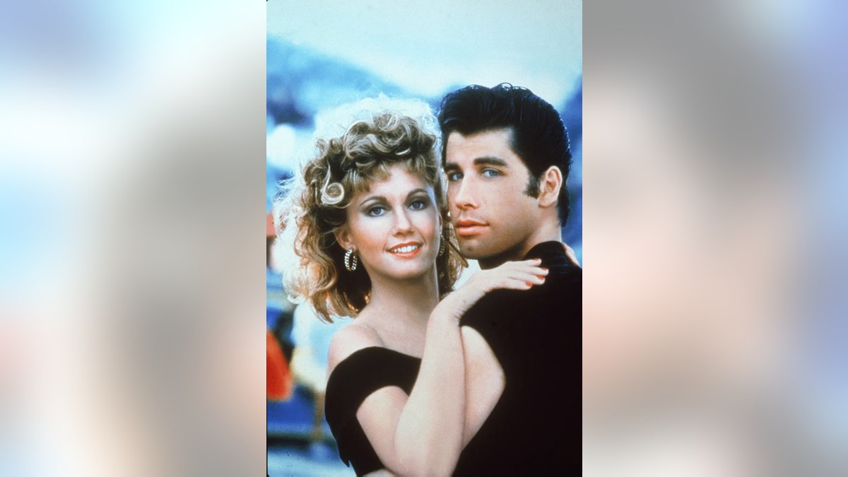 約翰·特拉沃爾塔(John Travolta)和奧利維亞·牛頓·約翰(Olivia Newton-John)在電影的促銷活動中擁抱 "塗抹。"