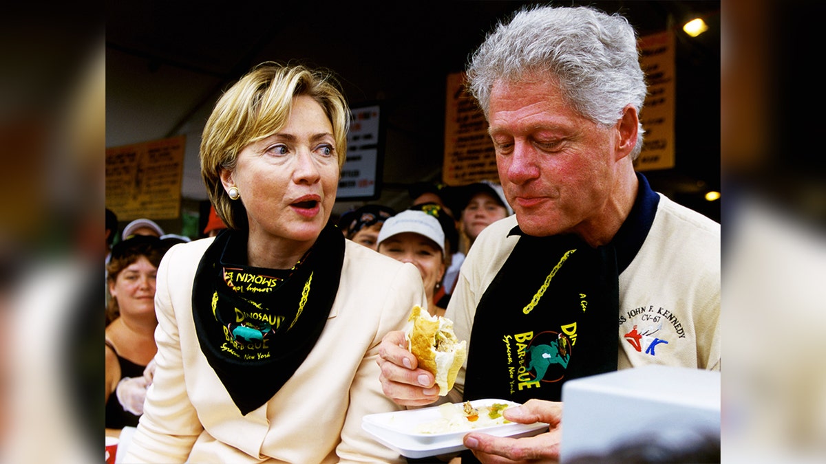 Hillary Clinton patrzy na ówczesnego prezydenta Billa Clintona jedzącego kanapkę