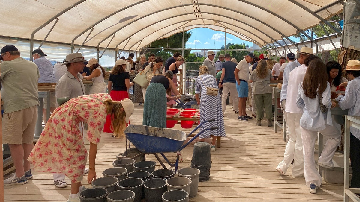 Women, men gathered under tent to dig through debris