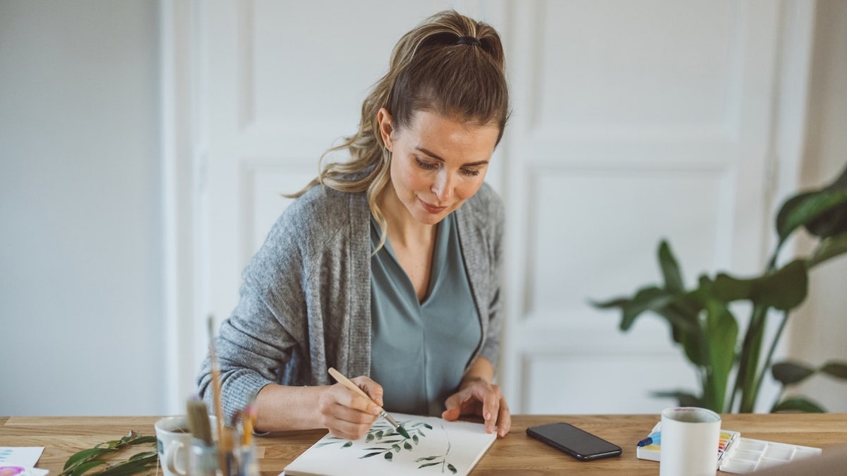 woman painting leaves