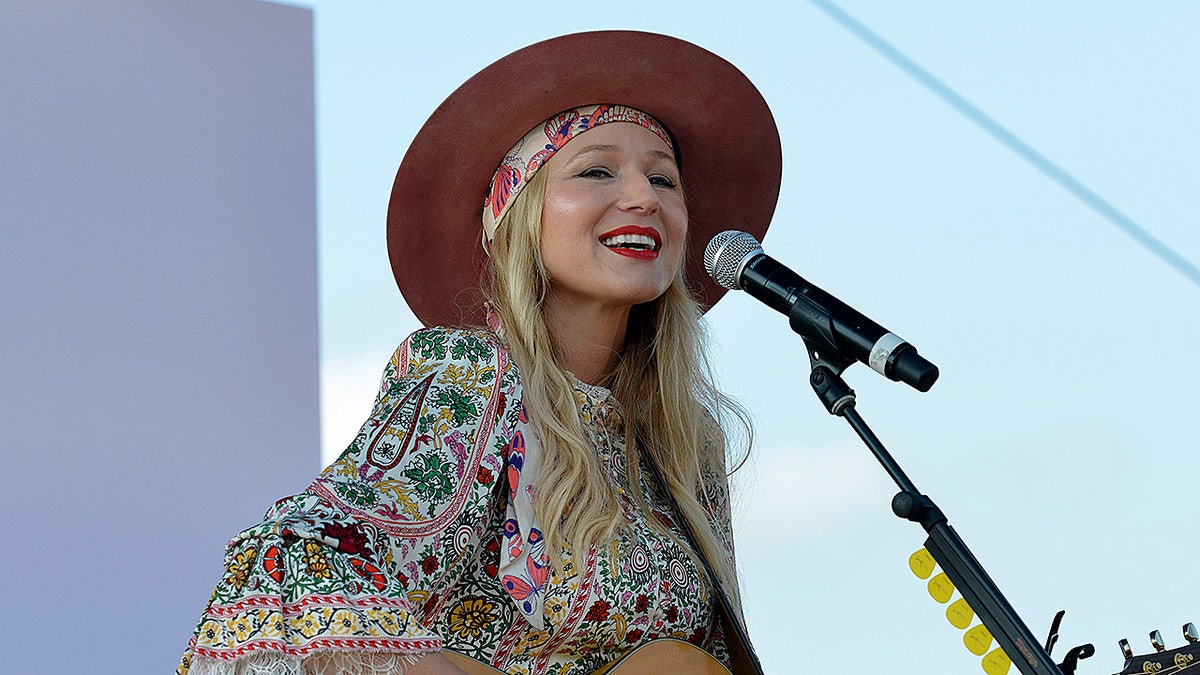Singer-songwriter Jewel playing guitar and singing on stage at The Wellness Experience in Cincinnati