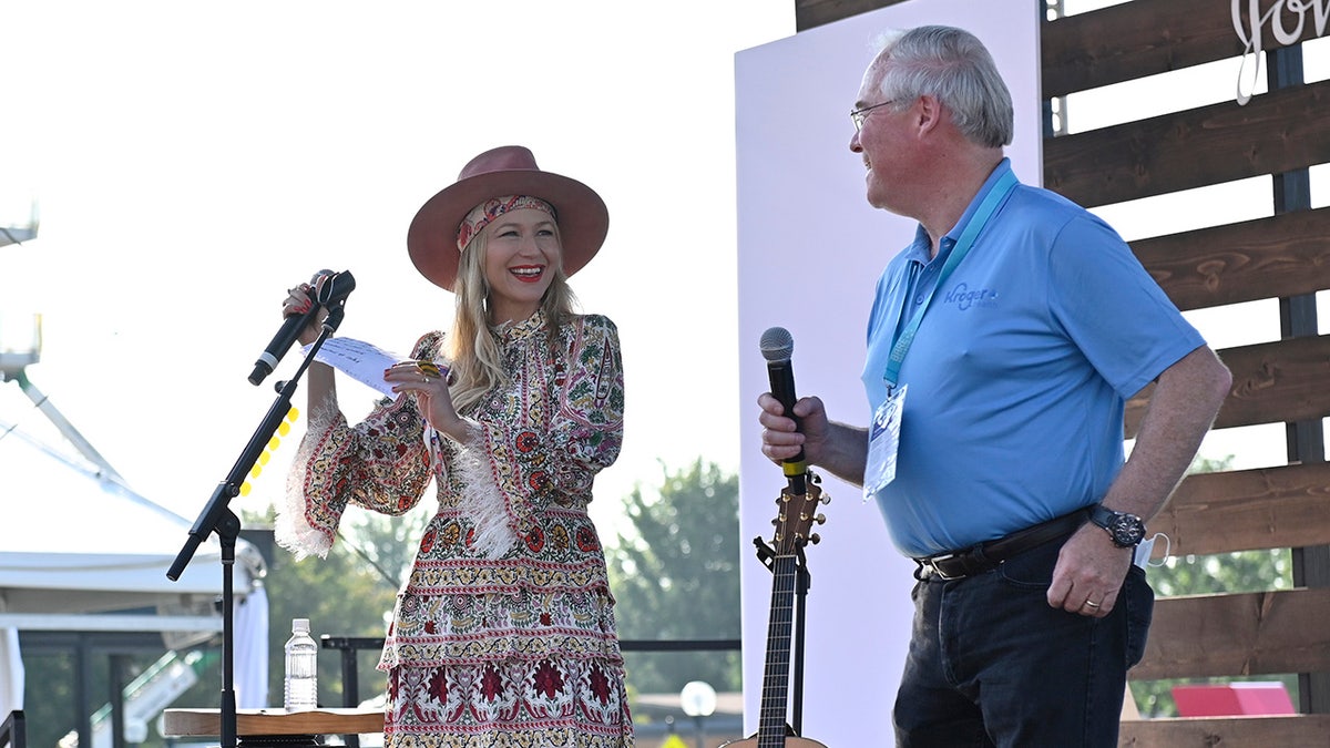 Jewel on stage with Rodney McMullen