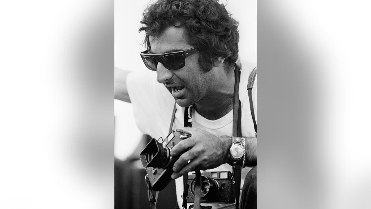 Jim Marshall holding multiple cameras.
