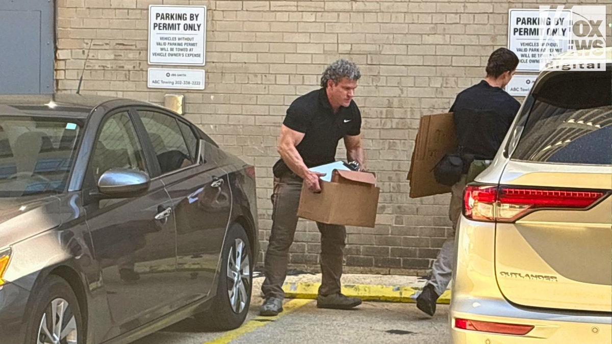 An FBI agent carries a box after a search at John Bolton’s D.C. office, Aug. 22, 2025.