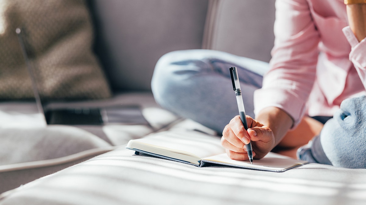 Woman journaling, only hands visible