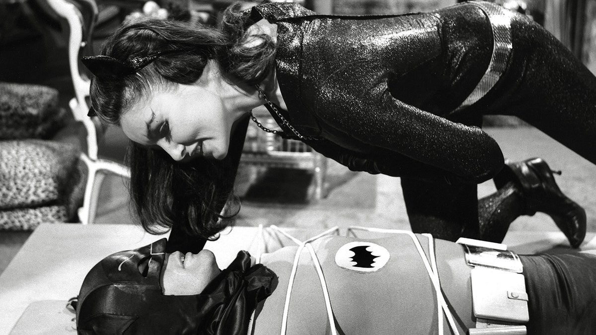 朱莉·紐馬爾(Julie Newmar)穿著貓女,在亞當·韋斯特(Adam West)上方,肯定是蝙蝠俠。亞當·韋斯特(Adam West)與繩子綁在一起。
