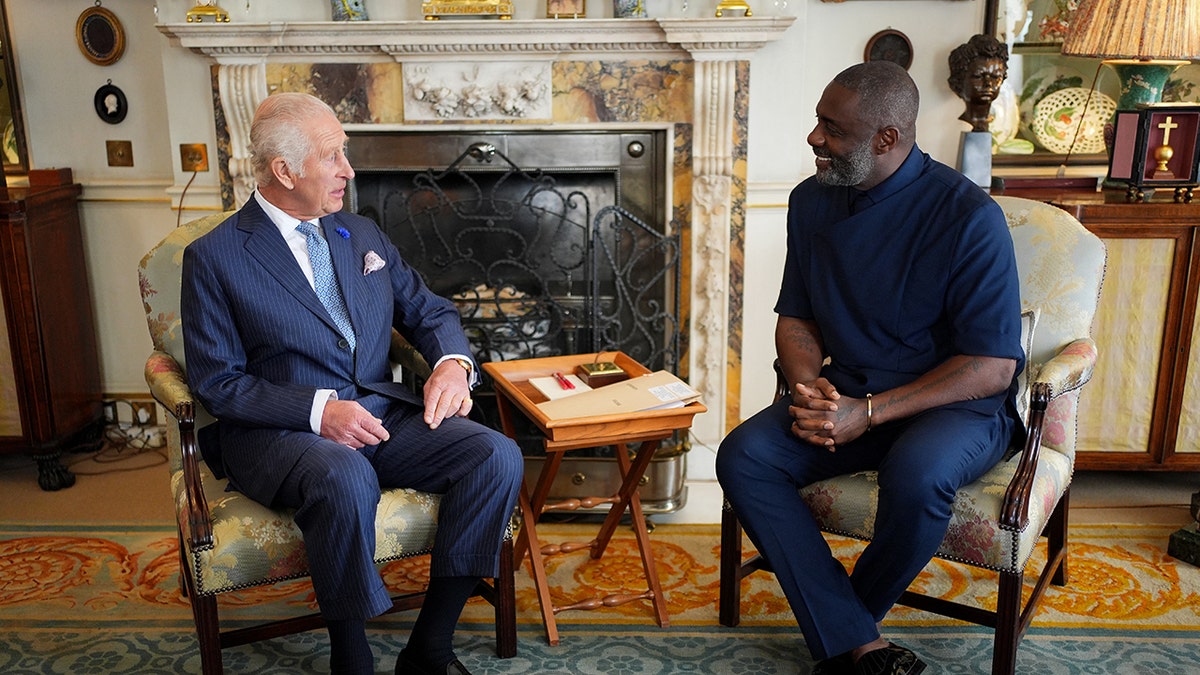 King Charles and Idris Elda sitting next to each other inside the palace in the U.K.