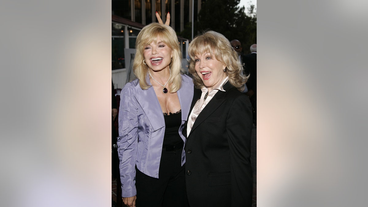 芭芭拉·伊甸園（Barbara Eden）和洛尼·安德森（Loni Anderson）笑了，而伊甸園·安德森（Eden Anderson）的兔子耳朵卻在她的腦海後面。