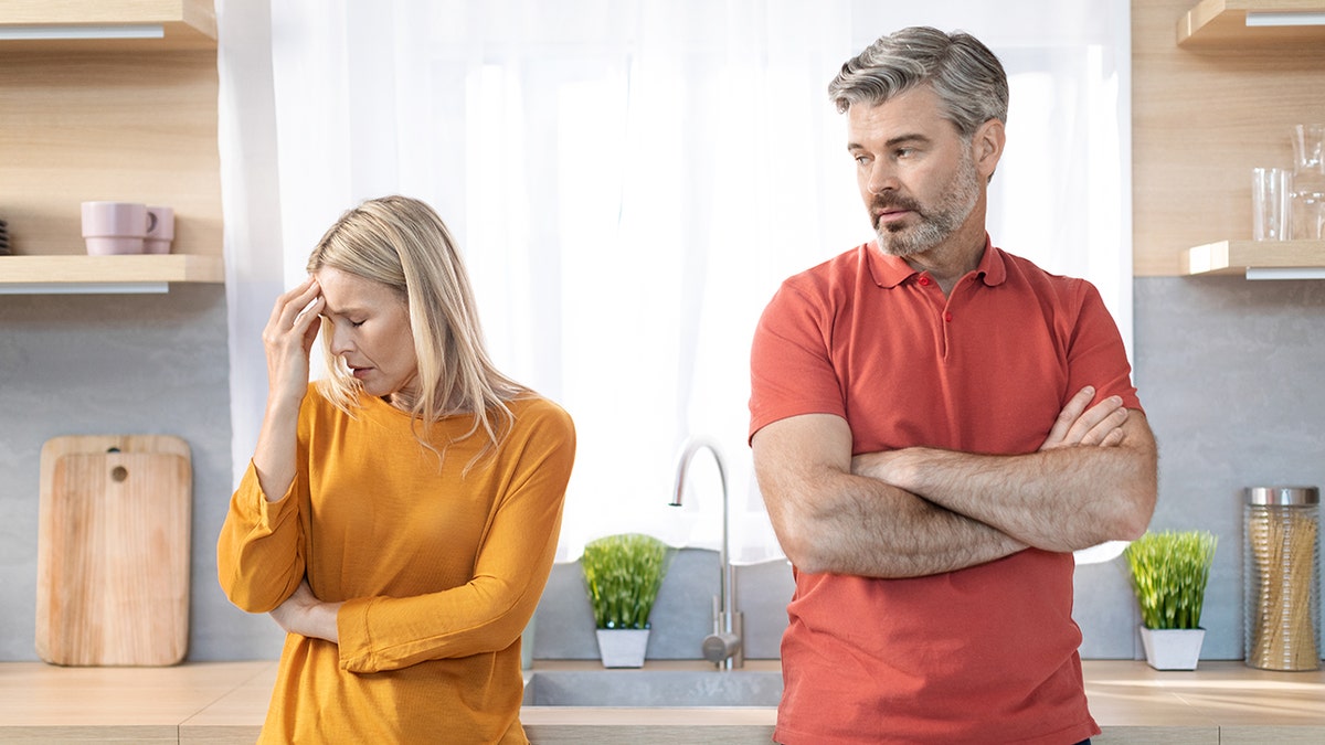 The man and woman appear to be at odds with each other in the kitchen.