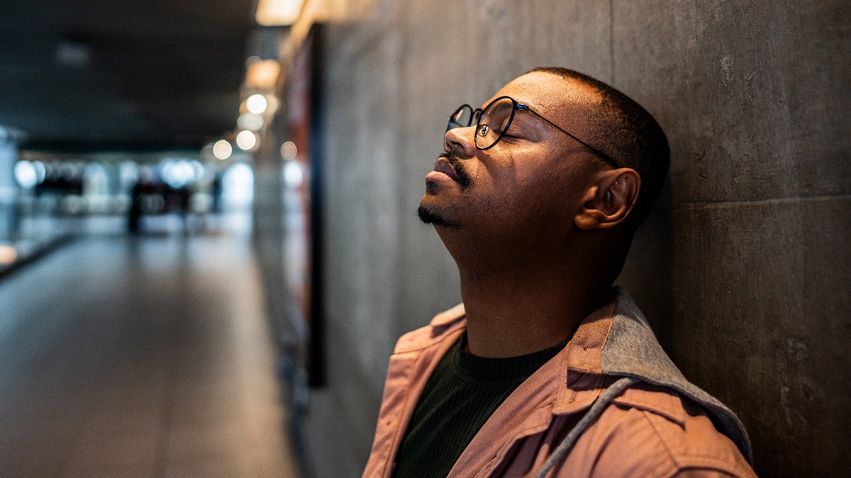 man taking a moment to relax at a train station