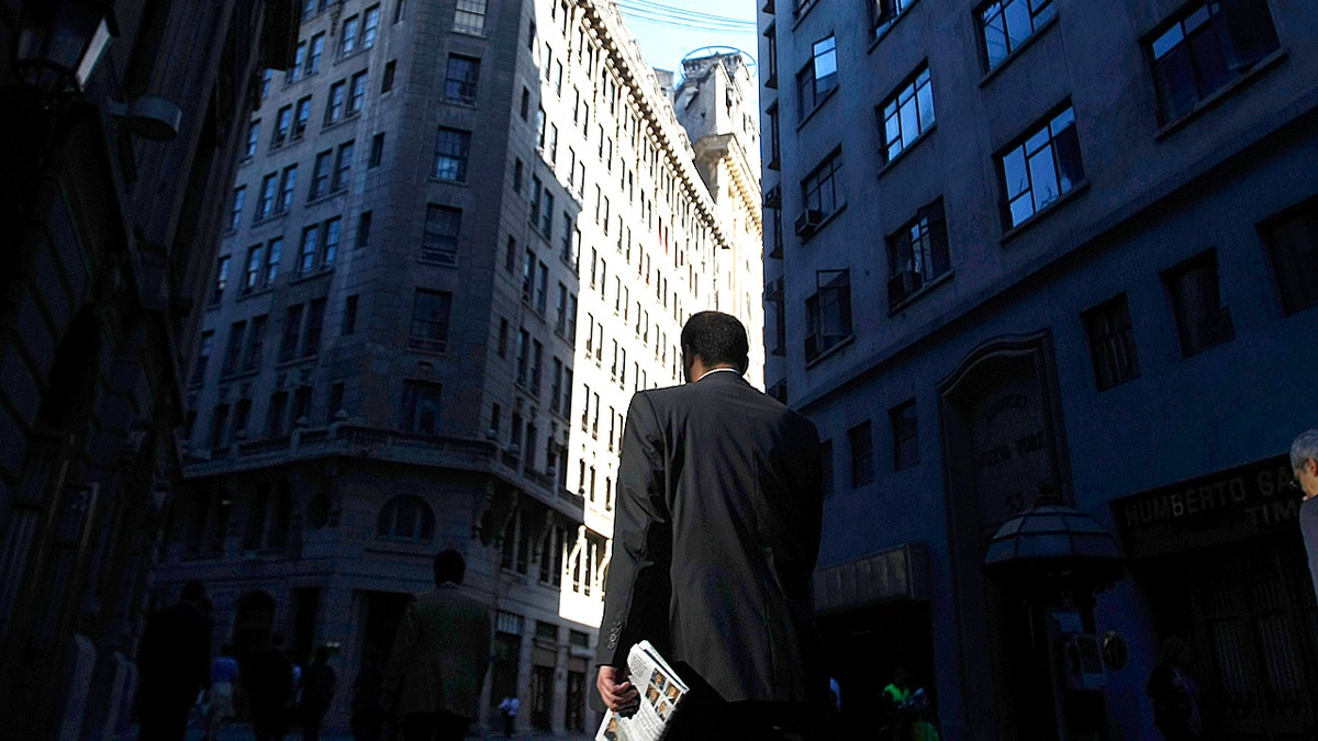 Microsoft study reveals which jobs AI impacts most and least in workplace 4 Men in suit walk through a financial district