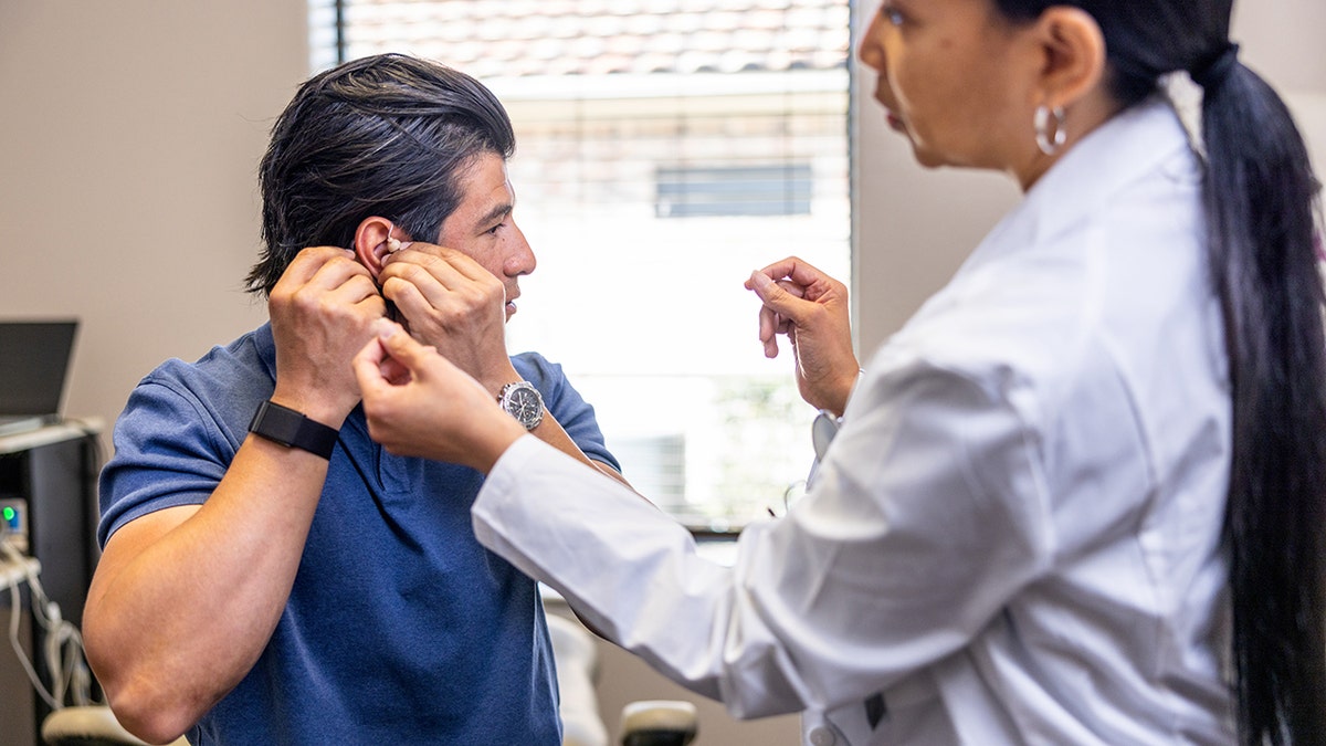 Man trying on a hearing aid