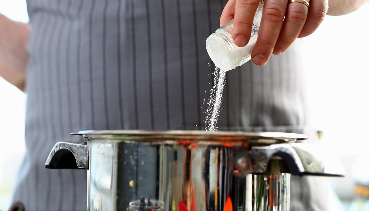 Man pouring salt into pot