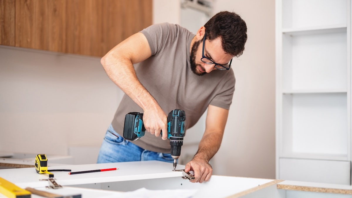 man using drill in home