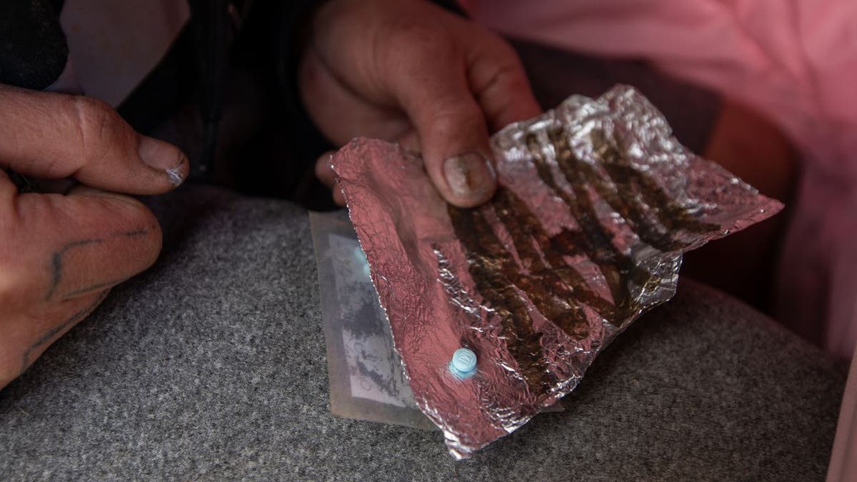 A man shows a fentanyl pill in Española, New Mexico