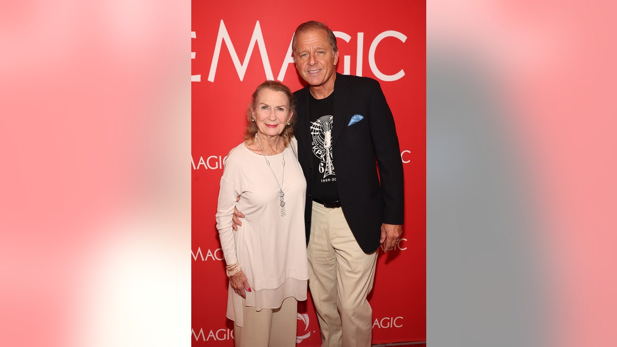 朱麗葉·米爾斯(Juliet Mills)帶著米色的笑容,站在紅地毯上的宏偉的麥克斯韋·考菲爾德(Maxwell Caulfield)旁邊。