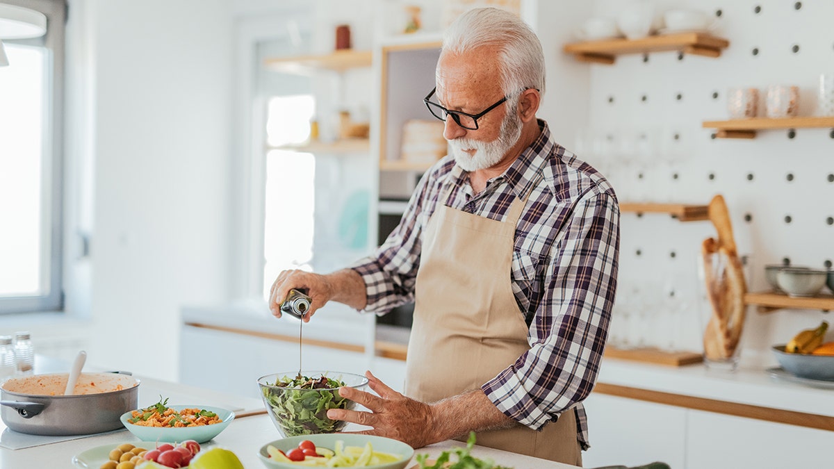 Hombre de cabello gris en casa cocinando en casa