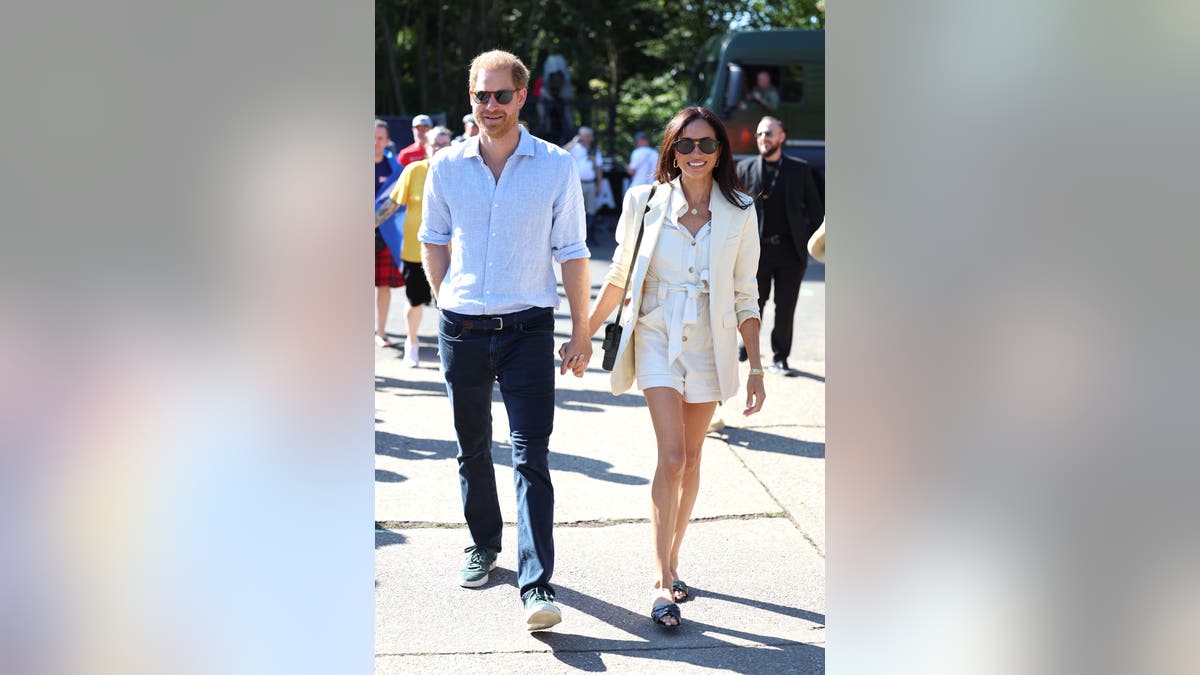 Meghan Markle holding hands with Prince Harry on a street