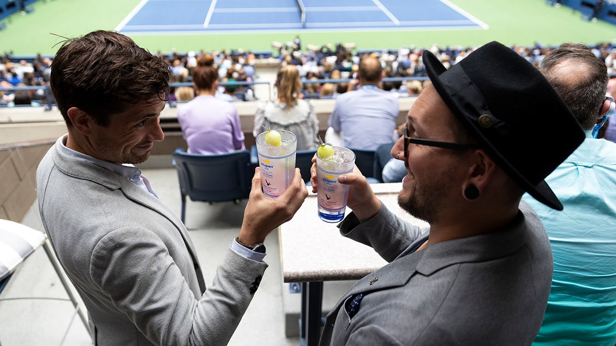 Two men toasting Honey Deuce cocktails at US open