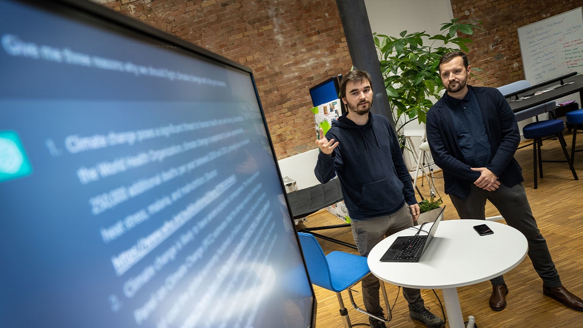 Dois homens que apresentam na tela grande no escritório
