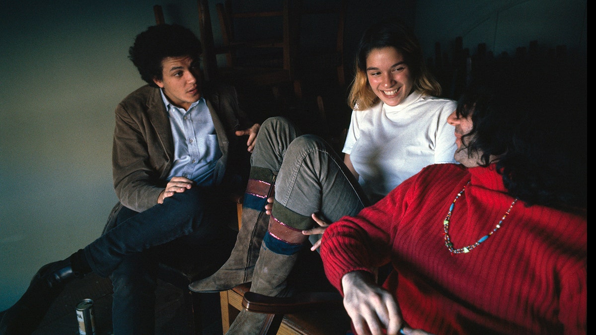 Mike Bloomfield, Mountain Girl and Jerry Garcia of the Grateful Dead sitting together in deep conversation.