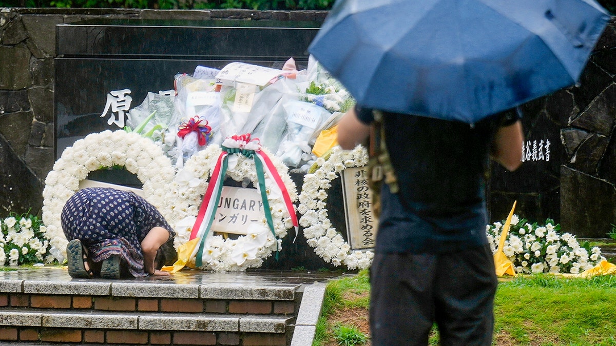 Sieviete lūdzas ceremonijā, godinot Nagasaki bombardēšanas upurus