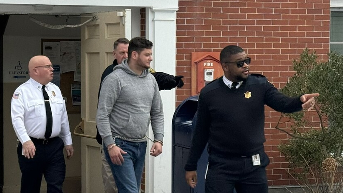 Authorities escort Francisco Fernandez Sanchez out of a town building in Nantucket 