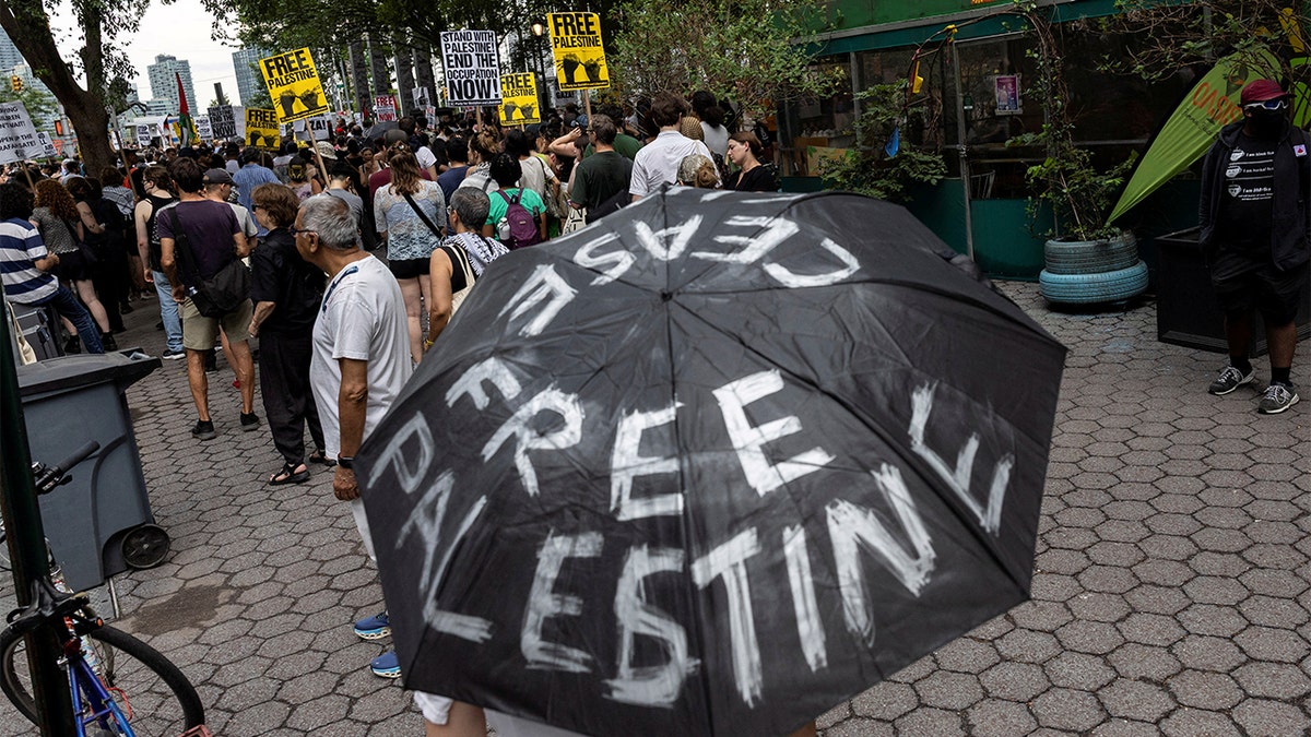 A demonstrator holds an umbrella with the words "Free Palestine" written on it in front of the United Nations headquarters during a "Stop Starving Gaza Now" protest amid the ongoing conflict between Israel and Hamas, in New York City, July 25, 2025.