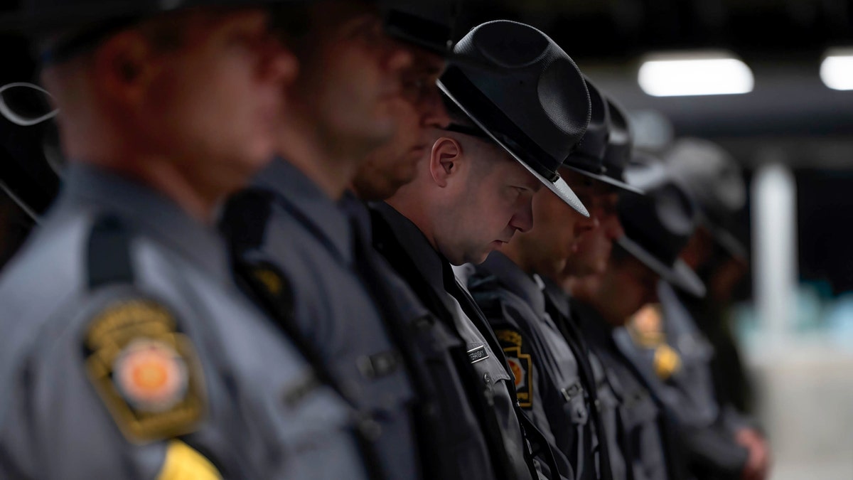 Pennsylvania State Police Trooper bowing his head during prayer at memorial service