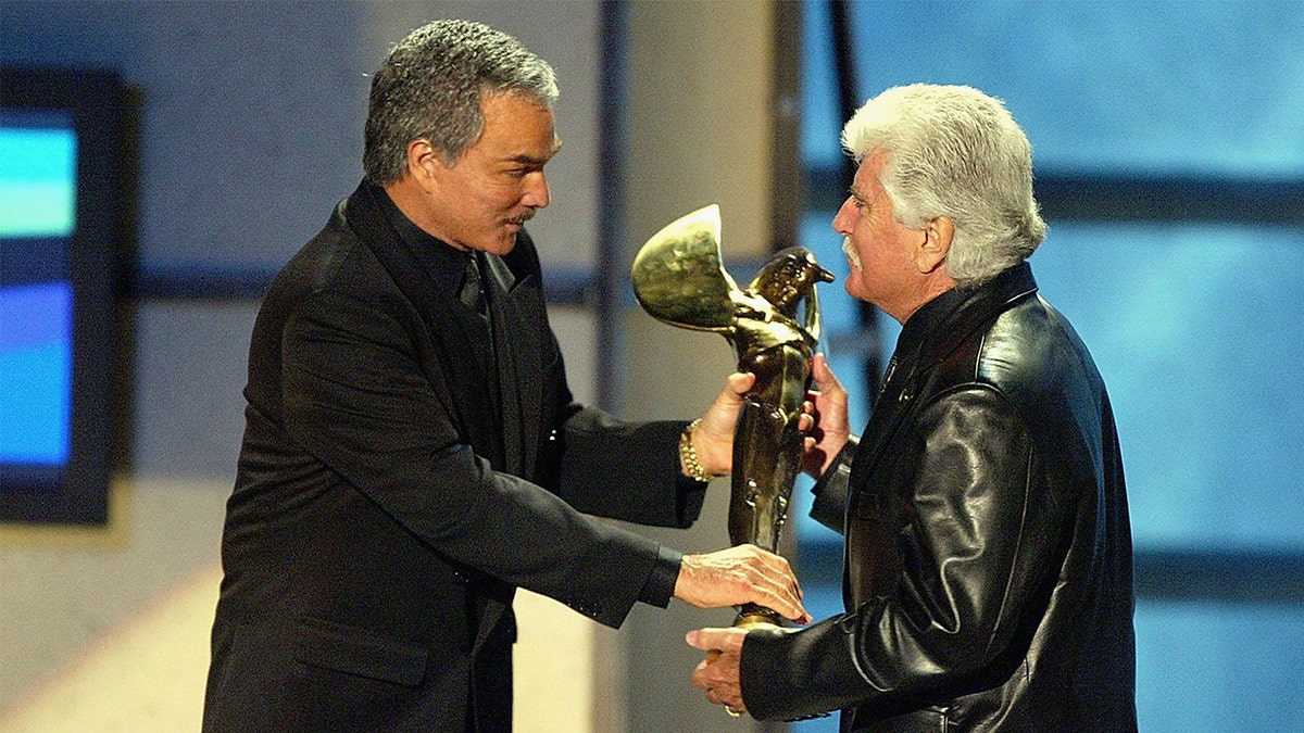 Rondell accepting award from Burt Reynolds