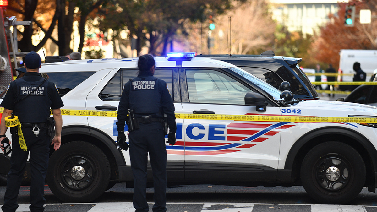 Police stand outside patrol car in Washington, DC