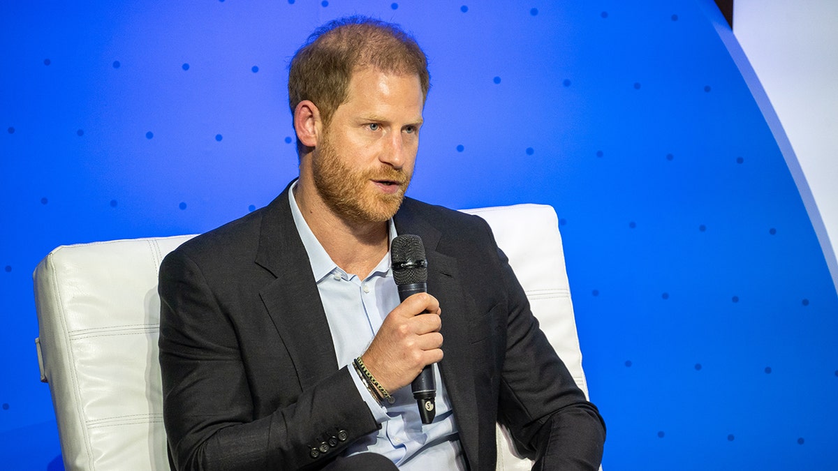 Prince Harry speaking to a mic at a conference.