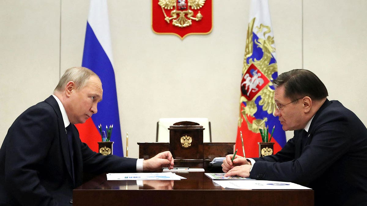 Putin sits with Rosatom's Alexey Likhachev