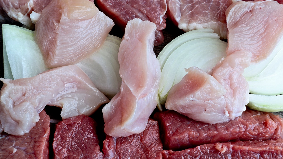 Coarsely chopped pieces of beef, pork, chicken, onion laid out together