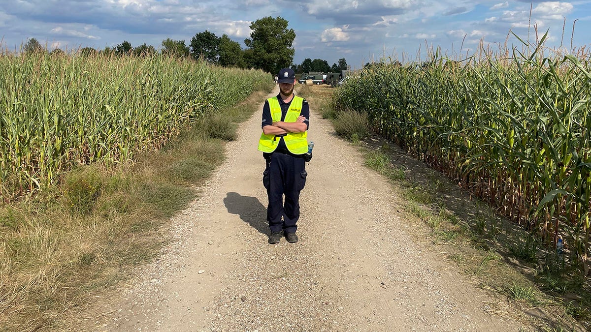 A Polish police officer at the scene where a Russian drone crashed in a cornfield.