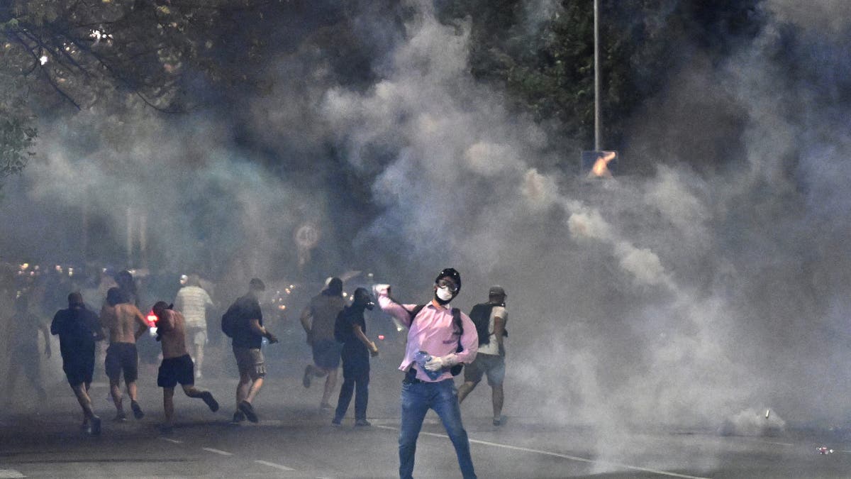 Los manifestantes están parados en la nube de gases lacrimógenos durante los manifestantes antigubernamentales en Belgrado el 16 de agosto de 2025. El choque comenzó la quinta noche de la agitación a fines del 16 de agosto de 2025.